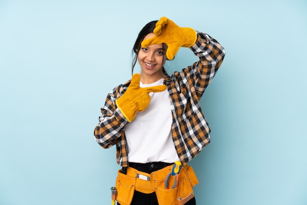 Photo young electrician woman on blue wall