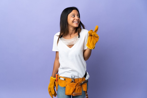 Young electrician woman isolated on purple intending to realizes the solution while lifting a finger up