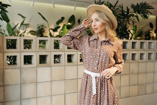 Young elegant girl posing indoor Pretty beautiful business woman in elegant dress at the wall