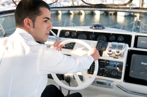 Young elegant man at yacht control
