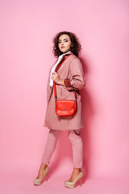 Young elegant woman in trendy pink coat