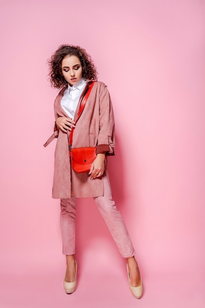 Young elegant woman in trendy pink coat