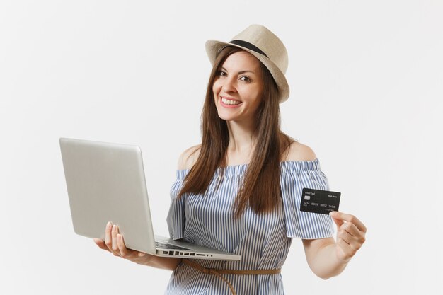 Young elegant woman working on modern laptop pc computer, holding credit card, money isolated on white background. Finance, freelance, business, online shopping concept. Mobile Office. Advertising.