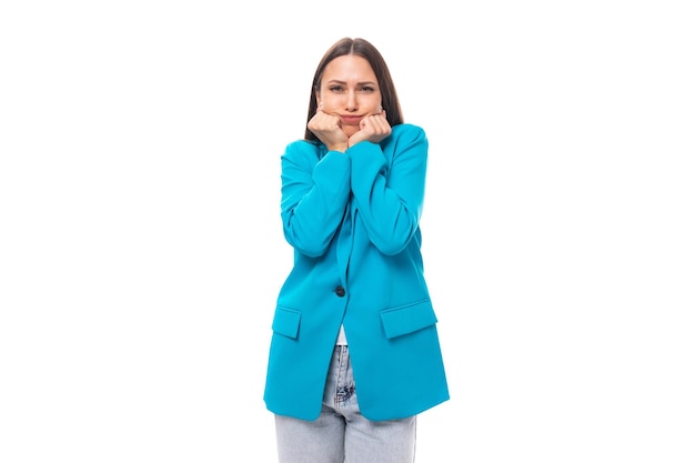 Молодая эмоциональная брюнетка-секретарь в синей куртке беспокоится о белом фоне с