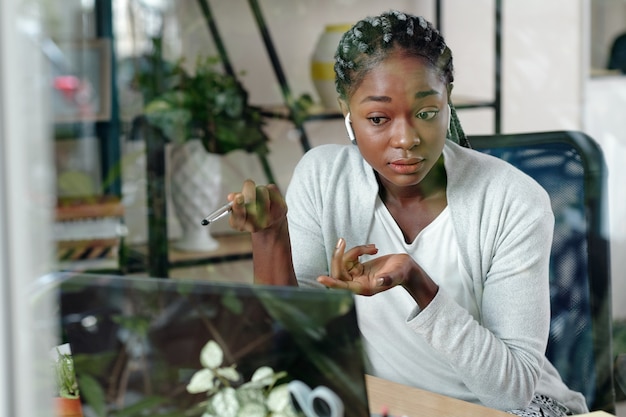 Photo young emotional businesswoman having online meeting with colleagues, they are discusing important issues like company development and sales