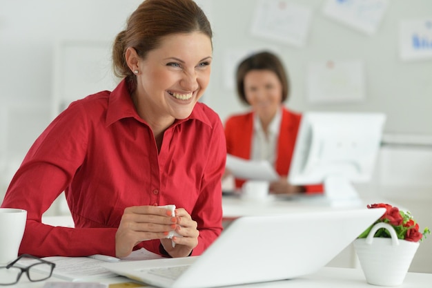 young emotional businesswomen working in modern office with laptop