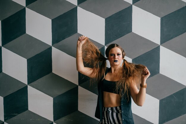 Young emotional clown girl posing in studio