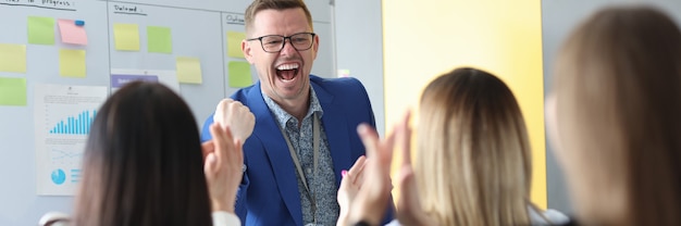 Young emotional male mentor conducts business briefing to colleagues