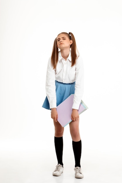 Young emotional pretty girl in uniform posing over white background