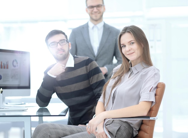 Young employee of the company on the background of business team