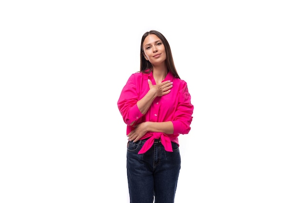 Young employee of an office company woman dressed in a pink shirt on a white background with copy