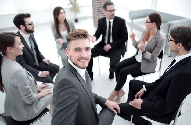 Young employee sitting in a circle with business teamthe concept of team building