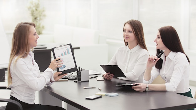 Young employees are talking sitting behind a desk