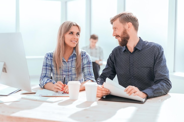 Young employees discussing financial documents in the office