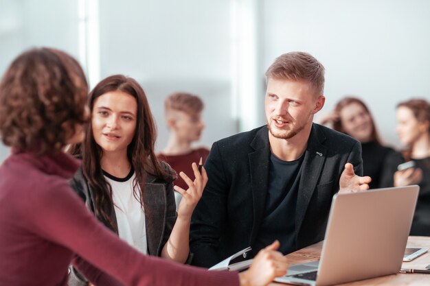 Young employees discussing work issues in the workplace