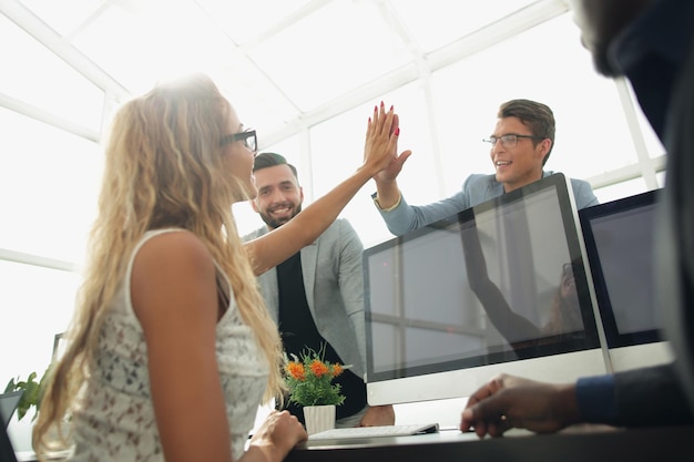 Young employees giving each other high fivethe concept of teamwork