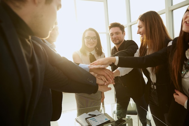 Young employees joining their palms over the Desk