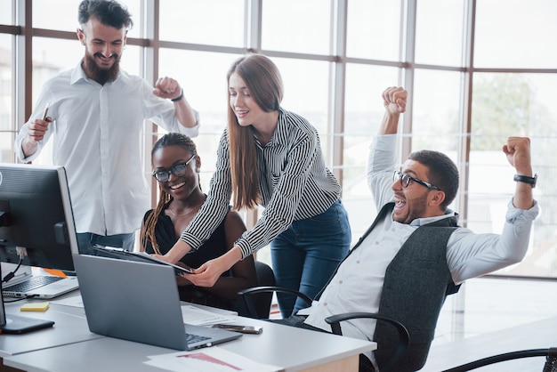 Giovani dipendenti seduti in ufficio al tavolo e utilizzando un laptop, un concetto di riunione di brainstorming di lavoro di squadra.