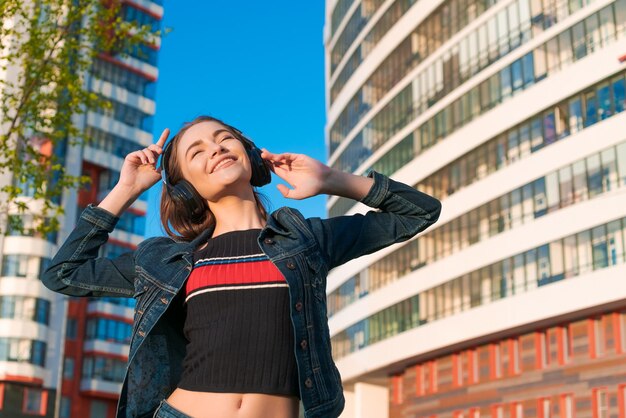 Young energetic cheerful caucasian woman wearing headphones Dressed in a denim