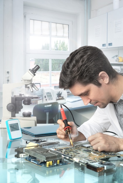 Young energetic male tech or engineer repairs electronic equipment