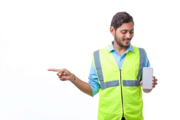 Young engineer showing smartphone screen on white background.