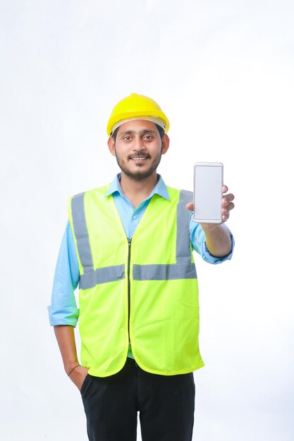 Young engineer showing smartphone screen on white background.