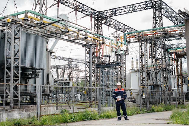 A young engineer stands in a mask at an electrical substation.