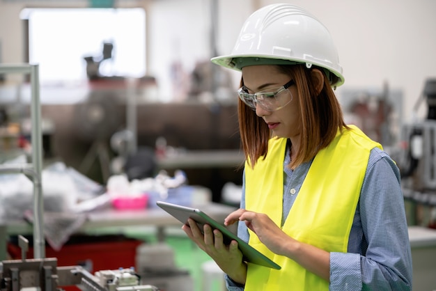 La giovane donna dell'ingegnere sta controllando la programmazione nella fabbrica di automazione.