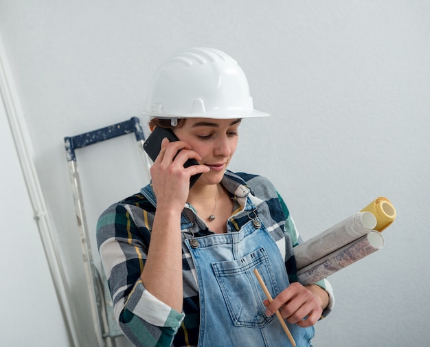 Young engineer woman with safety helmet talking on phone