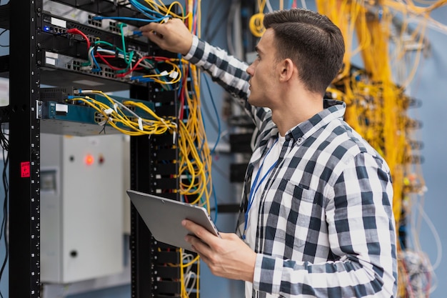 Photo young engineer working in server room with a tablet