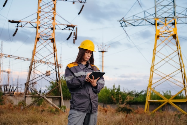 A young engineering worker inspects and controls the equipment of the power line. Energy.