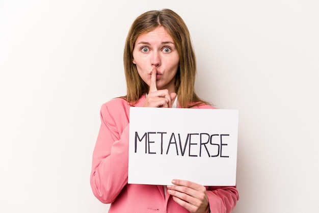 Young English business woman holding a metaverse placard isolated on white background keeping a secret or asking for silence.