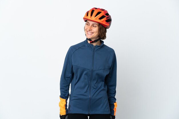 Young English cyclist woman on white looking to the side and smiling