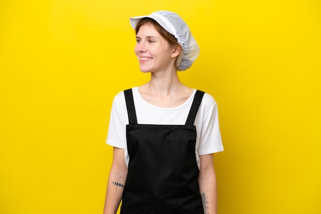 Young English fisherwoman isolated on yellow background looking side