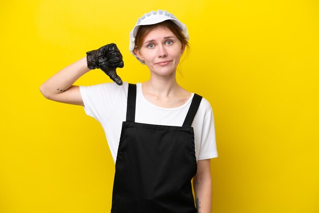 Young English fisherwoman isolated on yellow background showing thumb down with negative expression