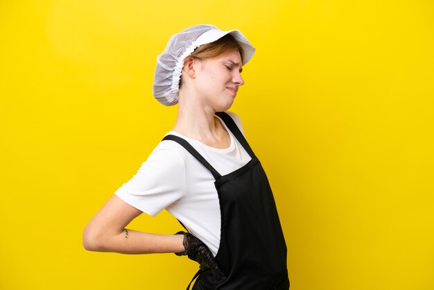 Photo young english fisherwoman isolated on yellow background suffering from backache for having made an effort