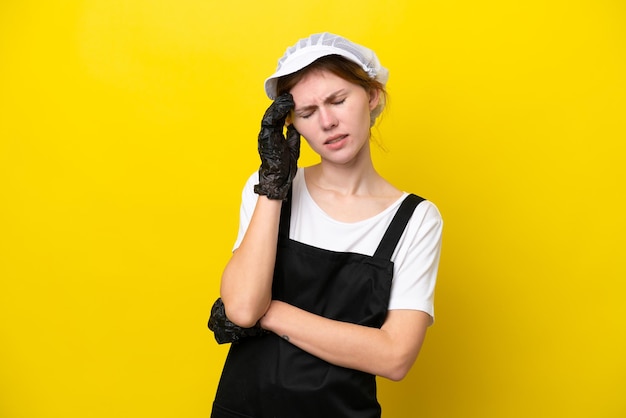 Young English fisherwoman isolated on yellow background with headache