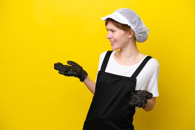Young English fisherwoman isolated on yellow background with surprise expression while looking side