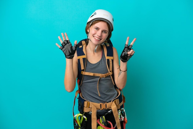 Young English rock climber woman isolated on blue background counting seven with fingers