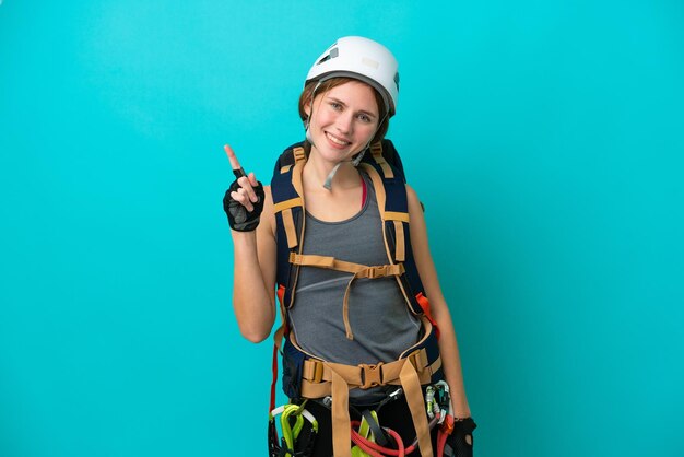 Young English rock climber woman isolated on blue background showing and lifting a finger in sign of the best