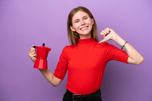 Young English woman holding coffee pot isolated on purple background proud and selfsatisfied