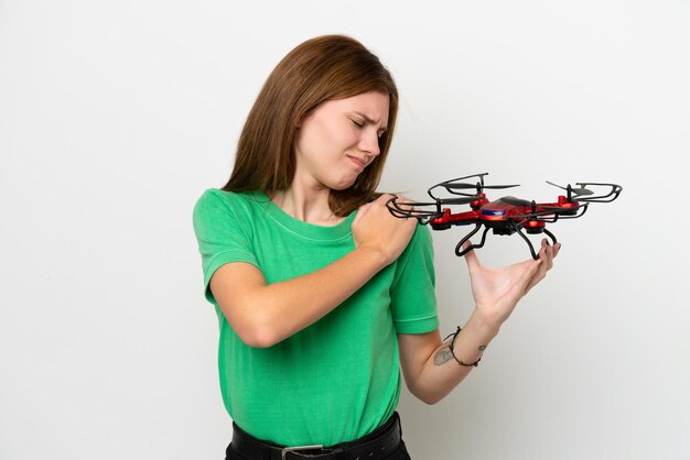 Young English woman holding a drone isolated on white background suffering from pain in shoulder for having made an effort