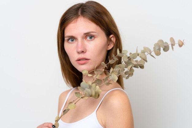 Young English woman holding a eucalyptus branch Close up portrait