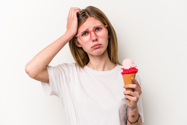 Giovane donna inglese in possesso di un gelato isolato su sfondo bianco scioccata ha ricordato un incontro importante