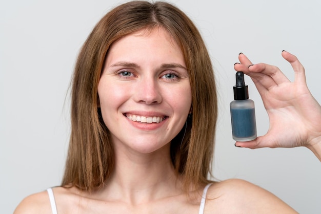 Young English woman holding a serum while smiling Close up portrait