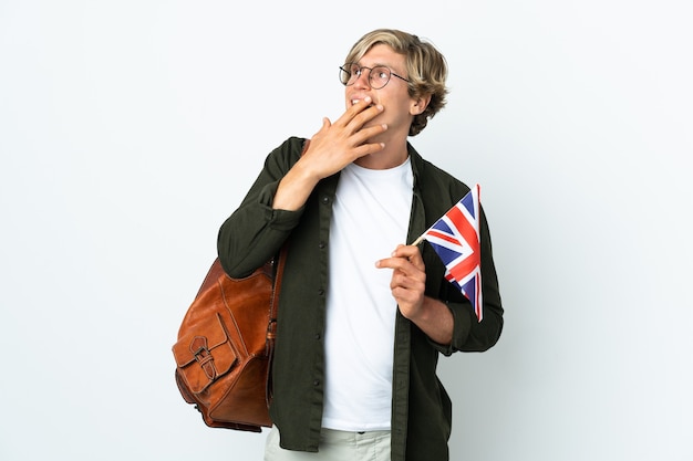 Young English woman holding an United Kingdom flag looking up while smiling