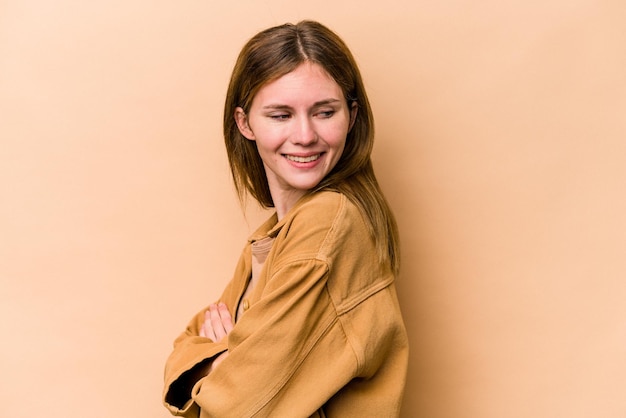 Young English woman isolated on beige background laughing and having fun