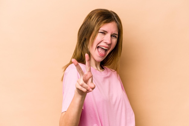 Young English woman isolated on beige background showing number two with fingers