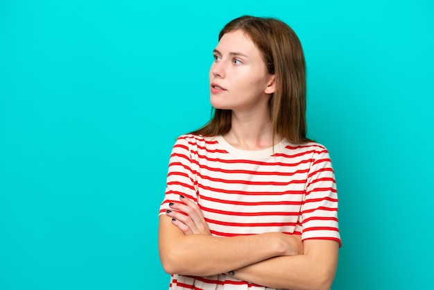 Young English woman isolated on blue background looking to the side