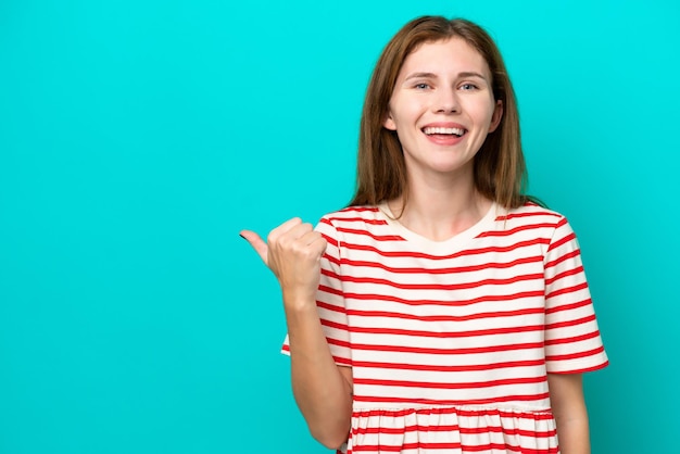 Young English woman isolated on blue background pointing to the side to present a product